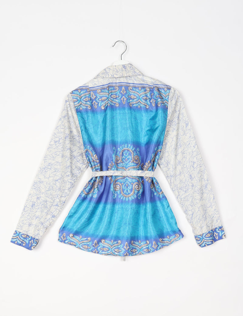 White shirt with blue tropical pattern, long sleeves, and belt, shown from the back on a hanger