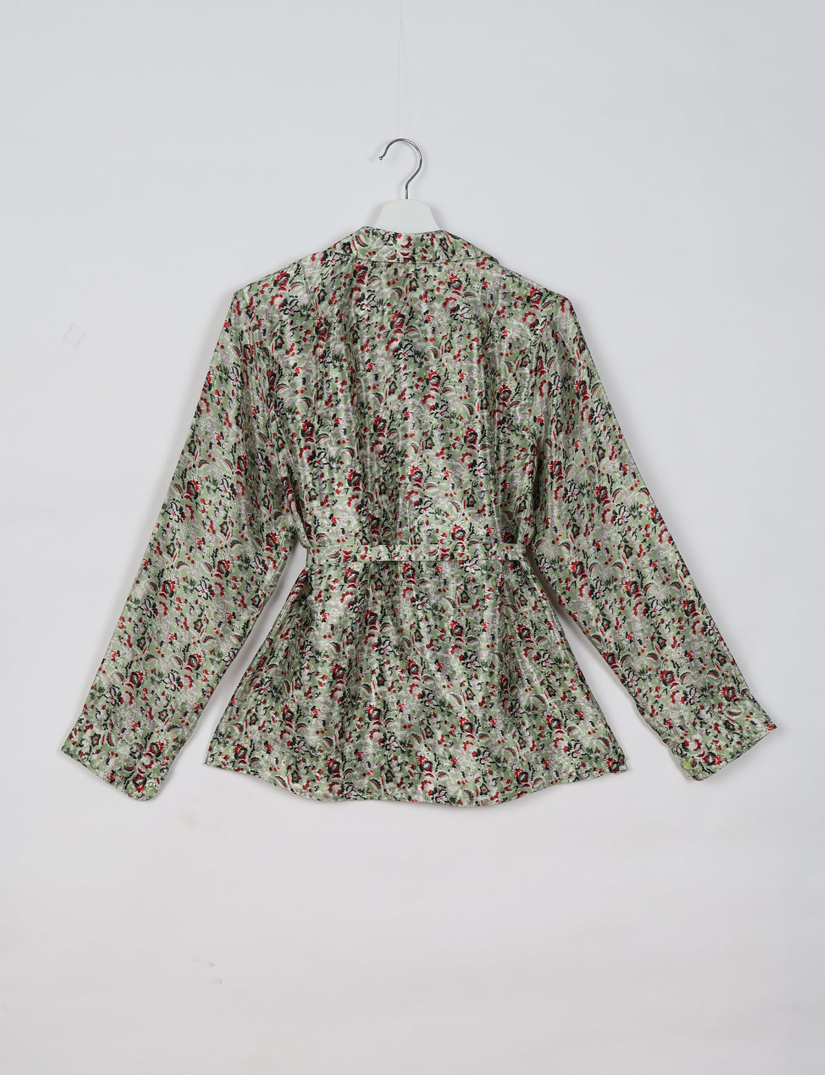 Beige tropical print long-sleeve shirt with belt detail, shown from back on white hanger against white background
