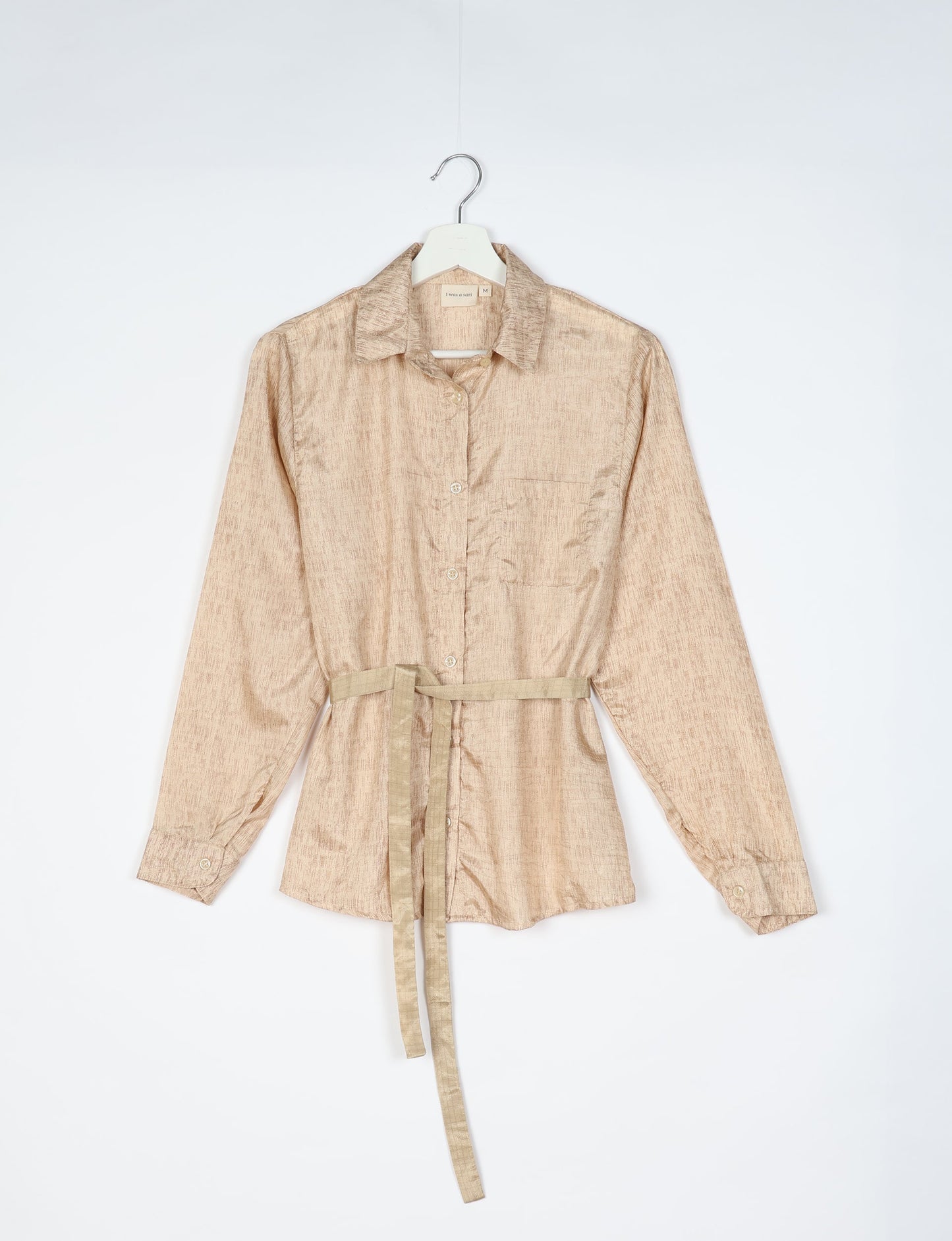 Experience sustainable fashion with our classic slim-fit shirt, crafted with ethical and green values. The shirt, designed for minimal waste, features a tie-up waist belt or neck tie, semi-spread collar, and regular shirt cuffs. Versatile and eco-friendly, wear it tucked in, unbuttoned over a tank top, or knotted at the waist for a unique style.