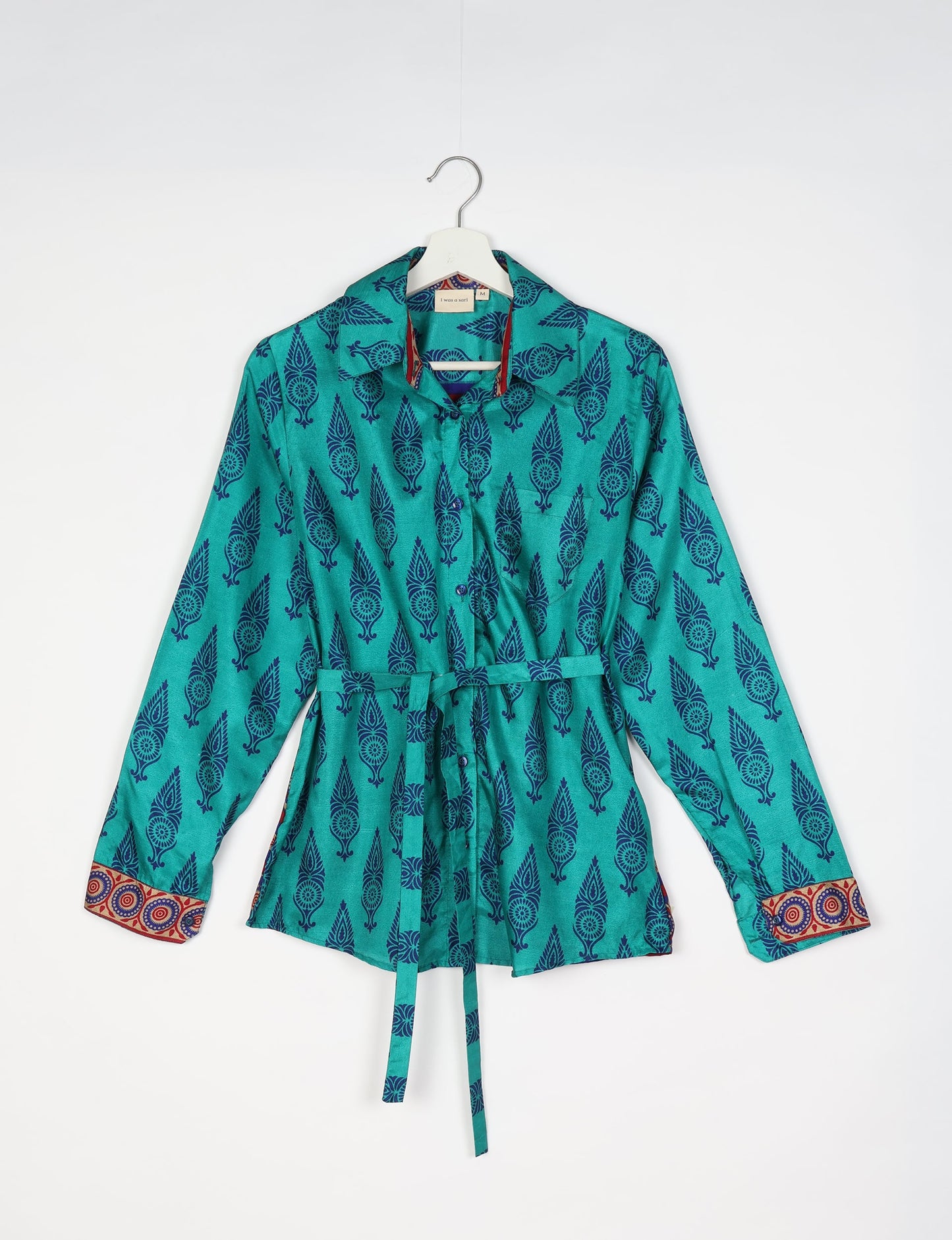 Experience sustainable fashion with our classic slim-fit shirt, crafted with ethical and green values. The shirt, designed for minimal waste, features a tie-up waist belt or neck tie, semi-spread collar, and regular shirt cuffs. Versatile and eco-friendly, wear it tucked in, unbuttoned over a tank top, or knotted at the waist for a unique style.