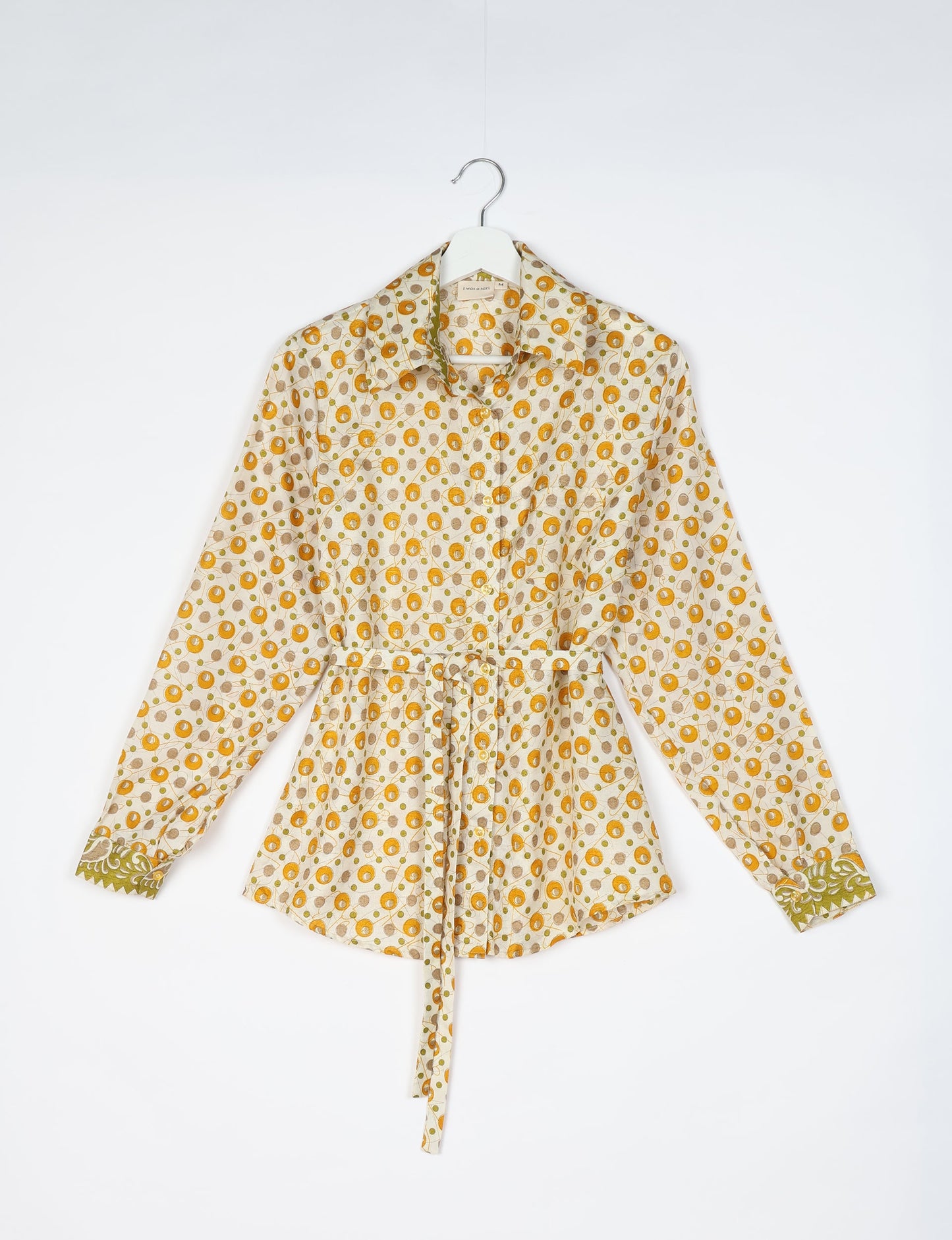 Experience sustainable fashion with our classic slim-fit shirt, crafted with ethical and green values. The shirt, designed for minimal waste, features a tie-up waist belt or neck tie, semi-spread collar, and regular shirt cuffs. Versatile and eco-friendly, wear it tucked in, unbuttoned over a tank top, or knotted at the waist for a unique style.