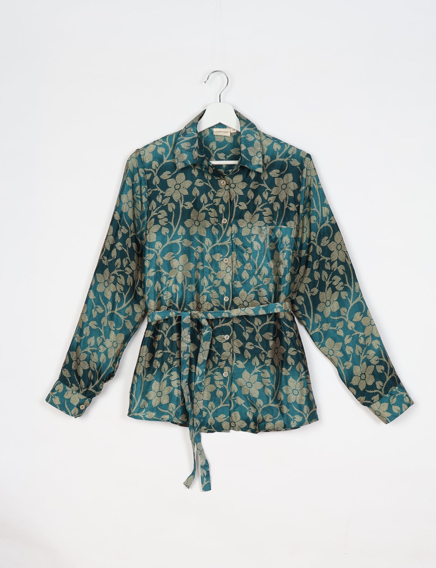 Experience sustainable fashion with our classic slim-fit shirt, crafted with ethical and green values. The shirt, designed for minimal waste, features a tie-up waist belt or neck tie, semi-spread collar, and regular shirt cuffs. Versatile and eco-friendly, wear it tucked in, unbuttoned over a tank top, or knotted at the waist for a unique style.