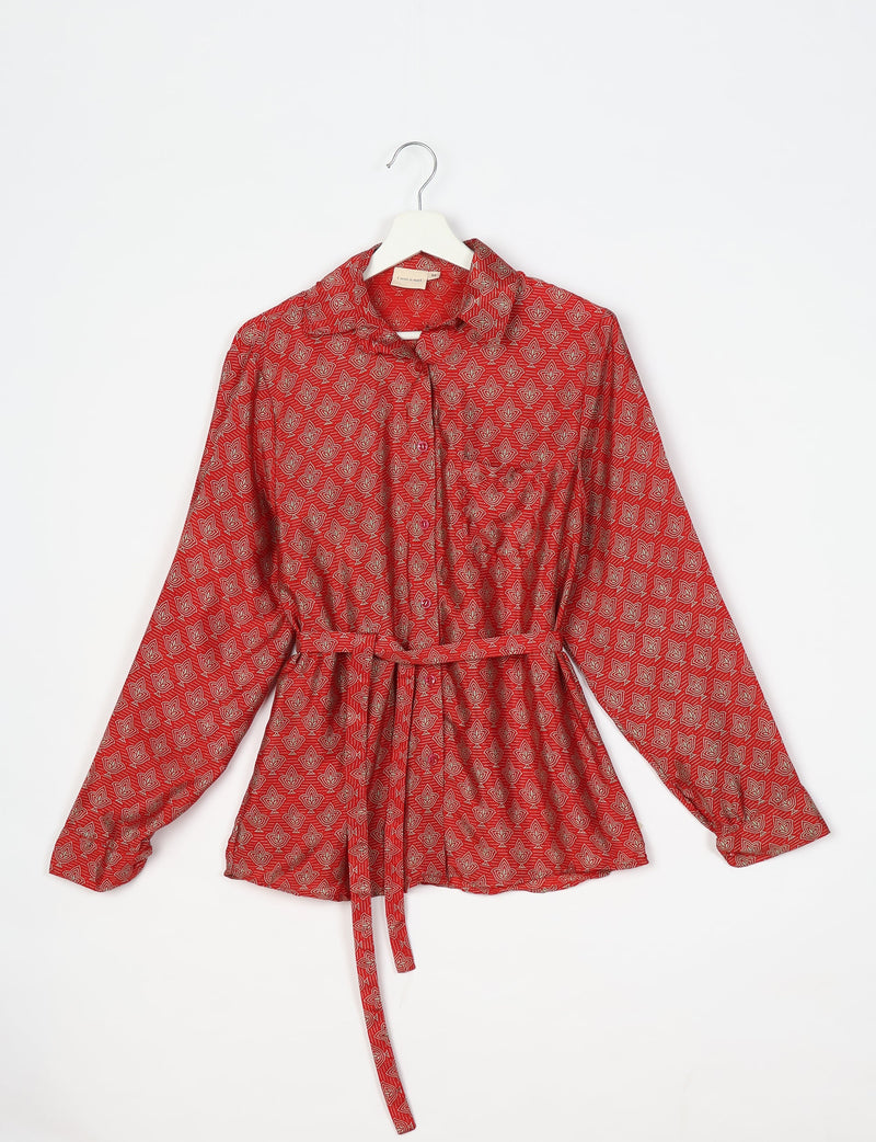 Red long-sleeve button-up shirt with beige leaf pattern, collar, chest pocket, and waist tie, hanging on white hanger