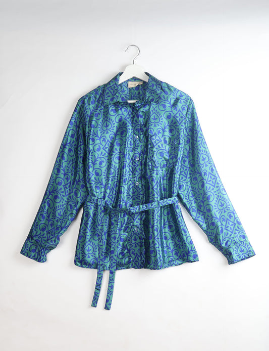 Experience sustainable fashion with our classic slim-fit shirt, crafted with ethical and green values. The shirt, designed for minimal waste, features a tie-up waist belt or neck tie, semi-spread collar, and regular shirt cuffs. Versatile and eco-friendly, wear it tucked in, unbuttoned over a tank top, or knotted at the waist for a unique style.