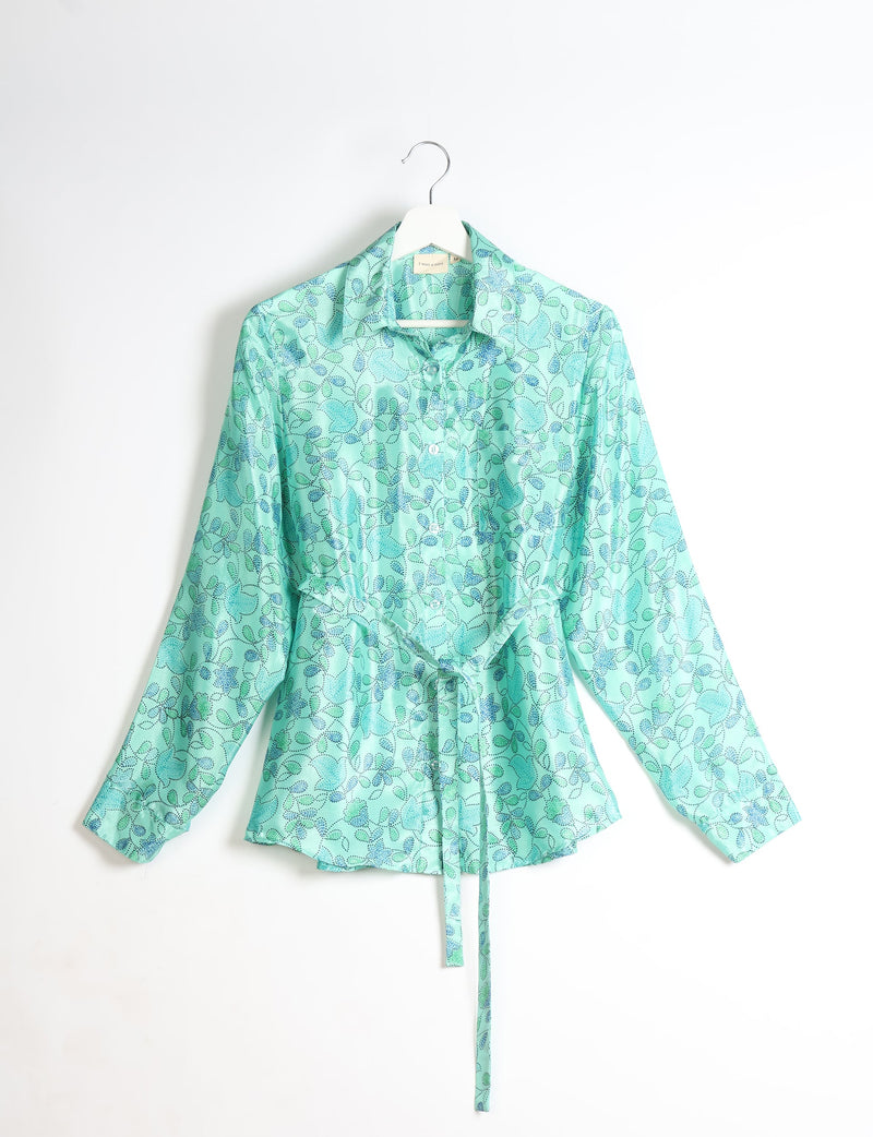 Green long-sleeve button-up shirt with blue and dark green floral pattern, collar, and waist tie, hanging on white hanger
