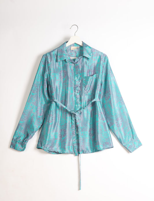 Experience sustainable fashion with our classic slim-fit shirt, crafted with ethical and green values. The shirt, designed for minimal waste, features a tie-up waist belt or neck tie, semi-spread collar, and regular shirt cuffs. Versatile and eco-friendly, wear it tucked in, unbuttoned over a tank top, or knotted at the waist for a unique style.