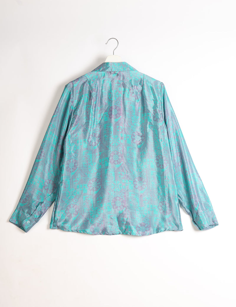 Blue long-sleeve shirt with tropical geometric and floral pattern, shown from back, hanging on white hanger