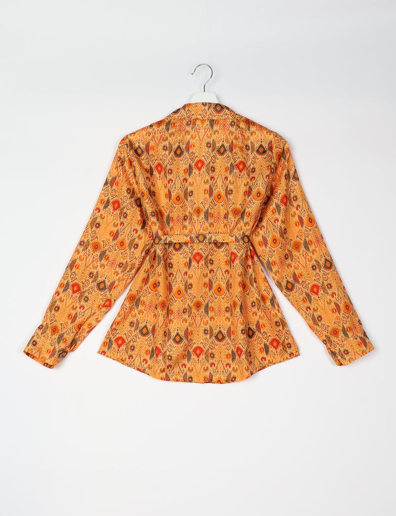 Orange ethnic patterned long-sleeve shirt with collar and belt detail, shown from back on white hanger against white background