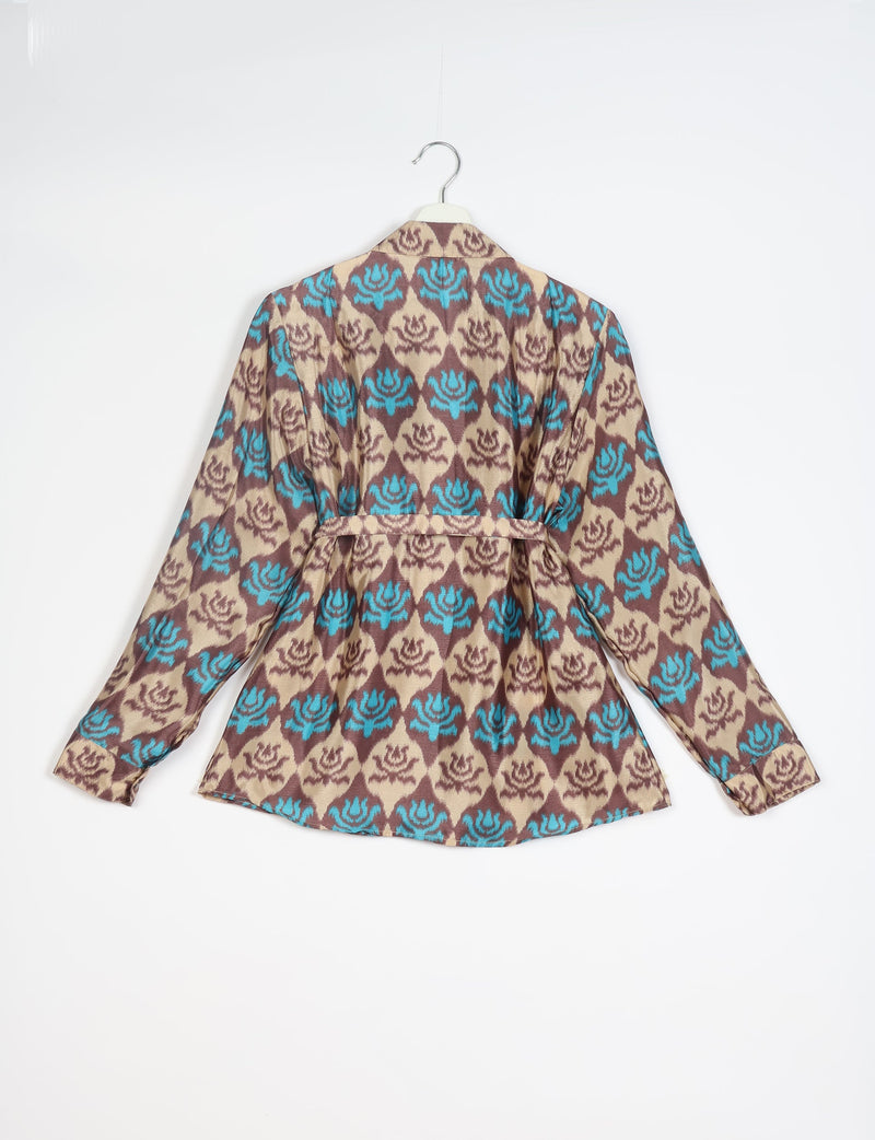 Long-sleeve shirt with blue and brown floral pattern on beige background, back view, hanging on white hanger