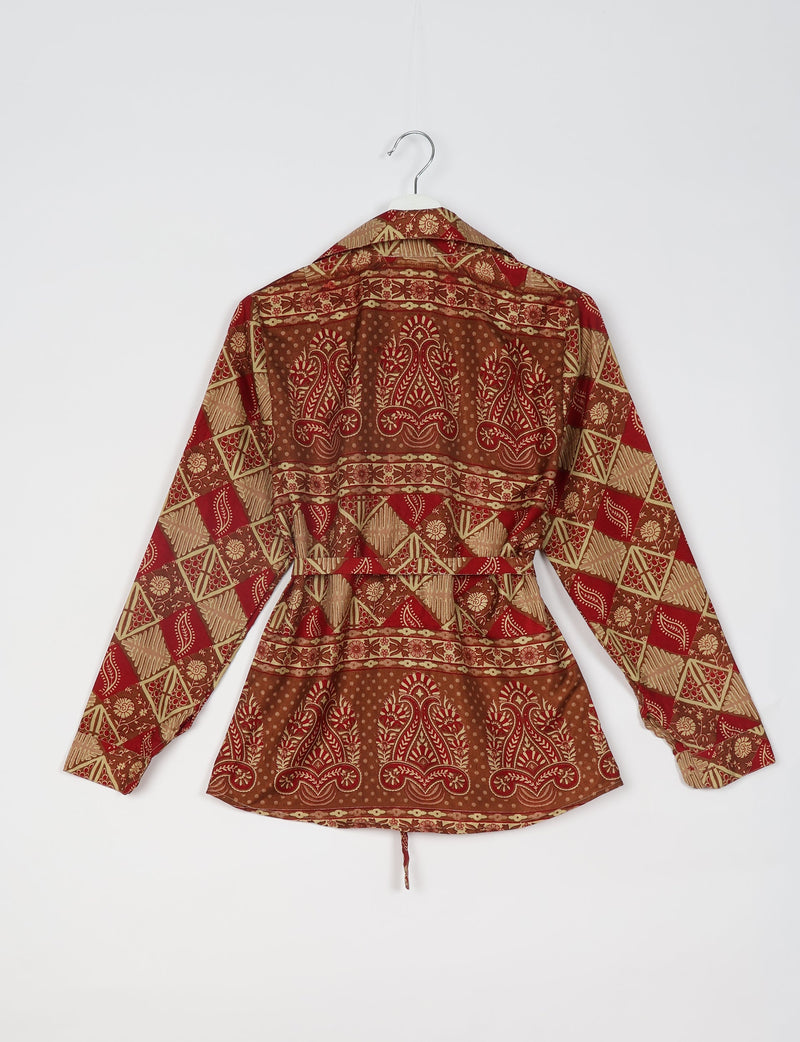 Red and brown geometric patterned long-sleeve shirt with floral and paisley motifs, shown from back on hanger