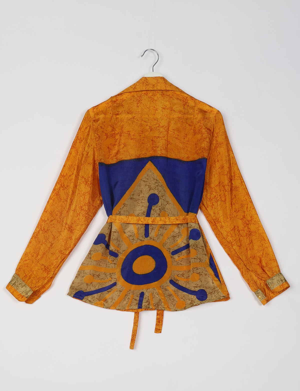 Orange and blue Indian ethnic shirt with long sleeves, abstract sun pattern, and back view on hanger against white background