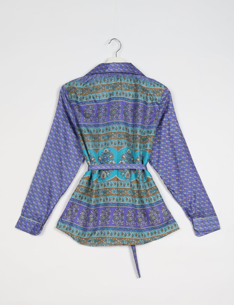 Blue and purple Indian ethnic shirt with floral and geometric patterns, long sleeves, collar, and waist tie, back view on hanger
