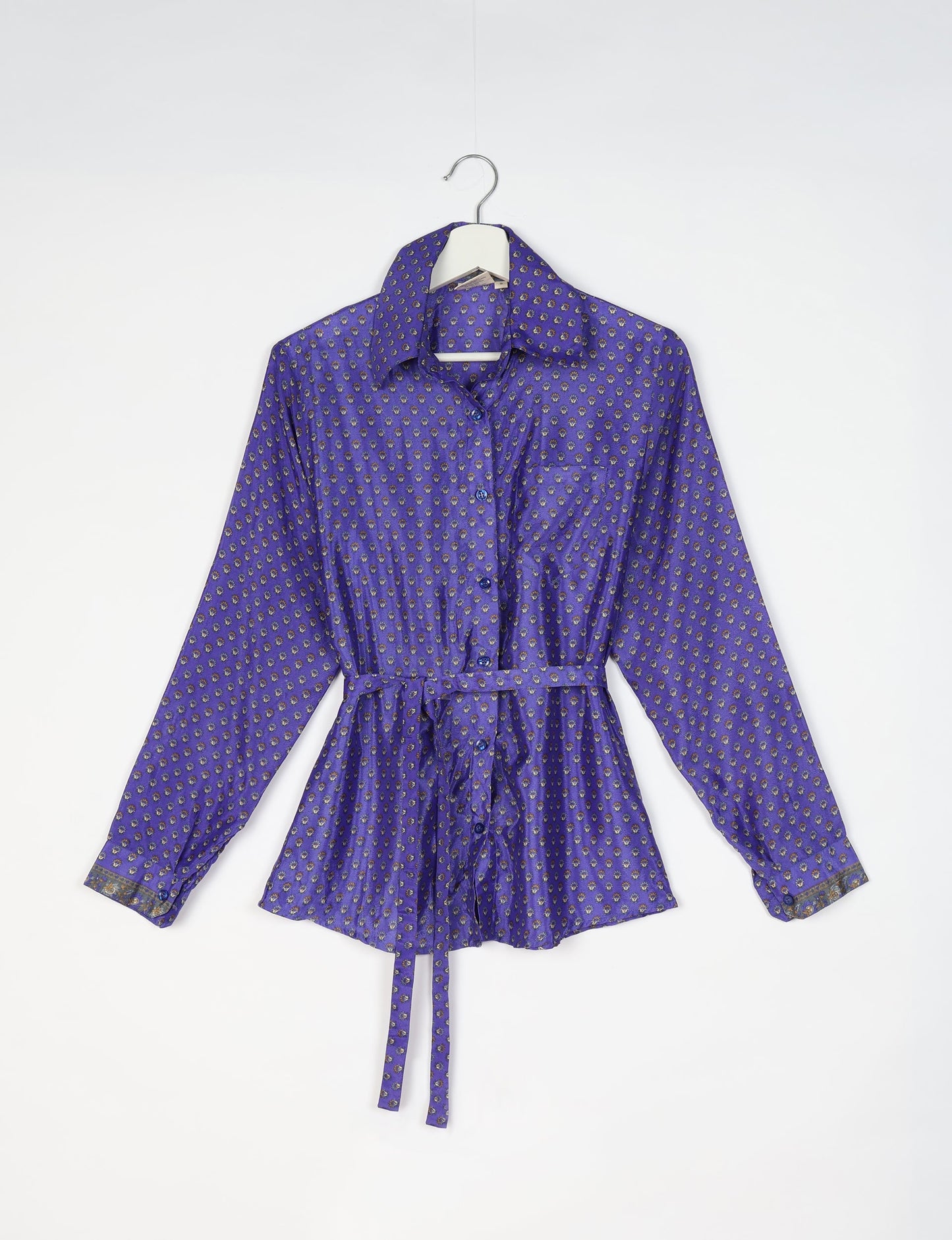 Experience sustainable fashion with our classic slim-fit shirt, crafted with ethical and green values. The shirt, designed for minimal waste, features a tie-up waist belt or neck tie, semi-spread collar, and regular shirt cuffs. Versatile and eco-friendly, wear it tucked in, unbuttoned over a tank top, or knotted at the waist for a unique style.