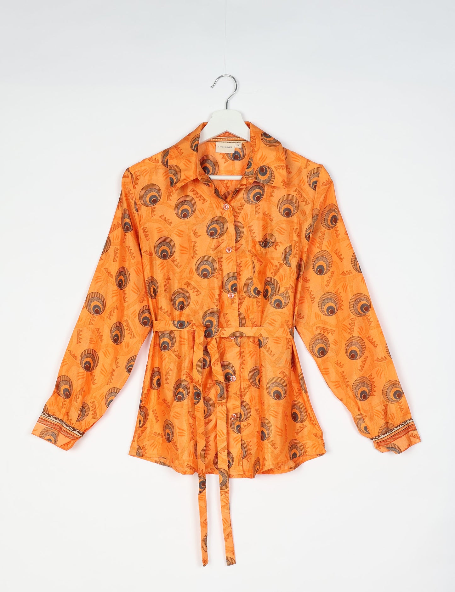 Experience sustainable fashion with our classic slim-fit shirt, crafted with ethical and green values. The shirt, designed for minimal waste, features a tie-up waist belt or neck tie, semi-spread collar, and regular shirt cuffs. Versatile and eco-friendly, wear it tucked in, unbuttoned over a tank top, or knotted at the waist for a unique style.