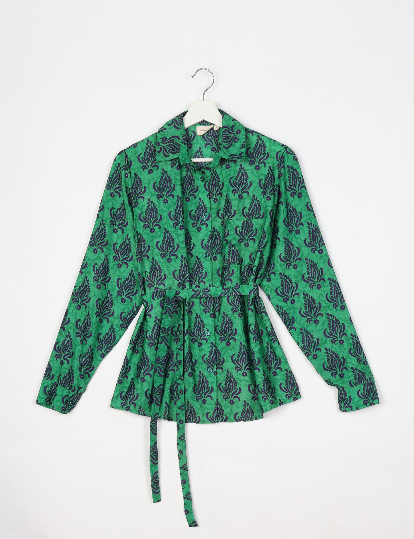 Experience sustainable fashion with our classic slim-fit shirt, crafted with ethical and green values. The shirt, designed for minimal waste, features a tie-up waist belt or neck tie, semi-spread collar, and regular shirt cuffs. Versatile and eco-friendly, wear it tucked in, unbuttoned over a tank top, or knotted at the waist for a unique style.