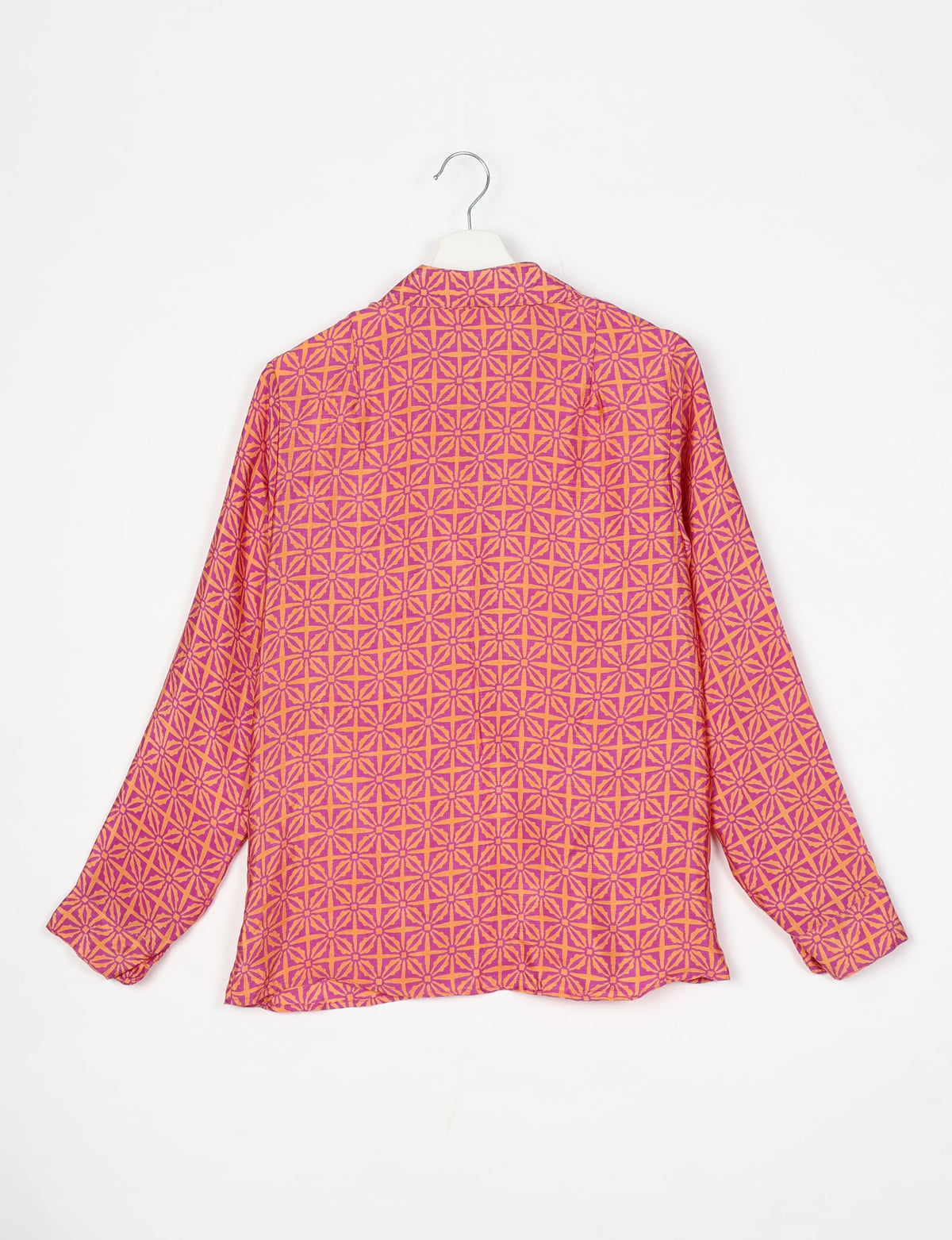 Long-sleeve shirt with pink and orange geometric leaf pattern, shown from back on white hanger against white background