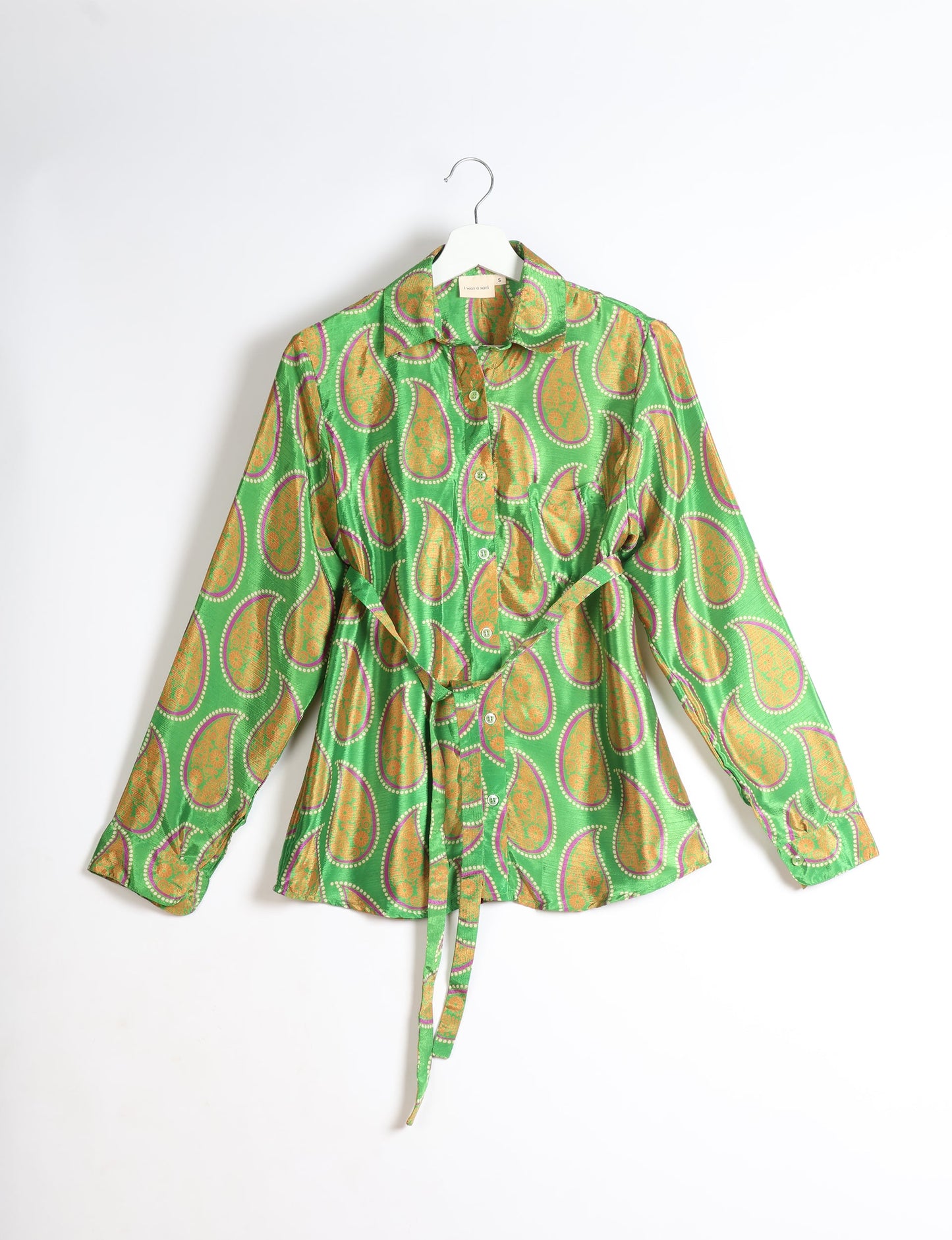 Experience sustainable fashion with our classic slim-fit shirt, crafted with ethical and green values. The shirt, designed for minimal waste, features a tie-up waist belt or neck tie, semi-spread collar, and regular shirt cuffs. Versatile and eco-friendly, wear it tucked in, unbuttoned over a tank top, or knotted at the waist for a unique style.