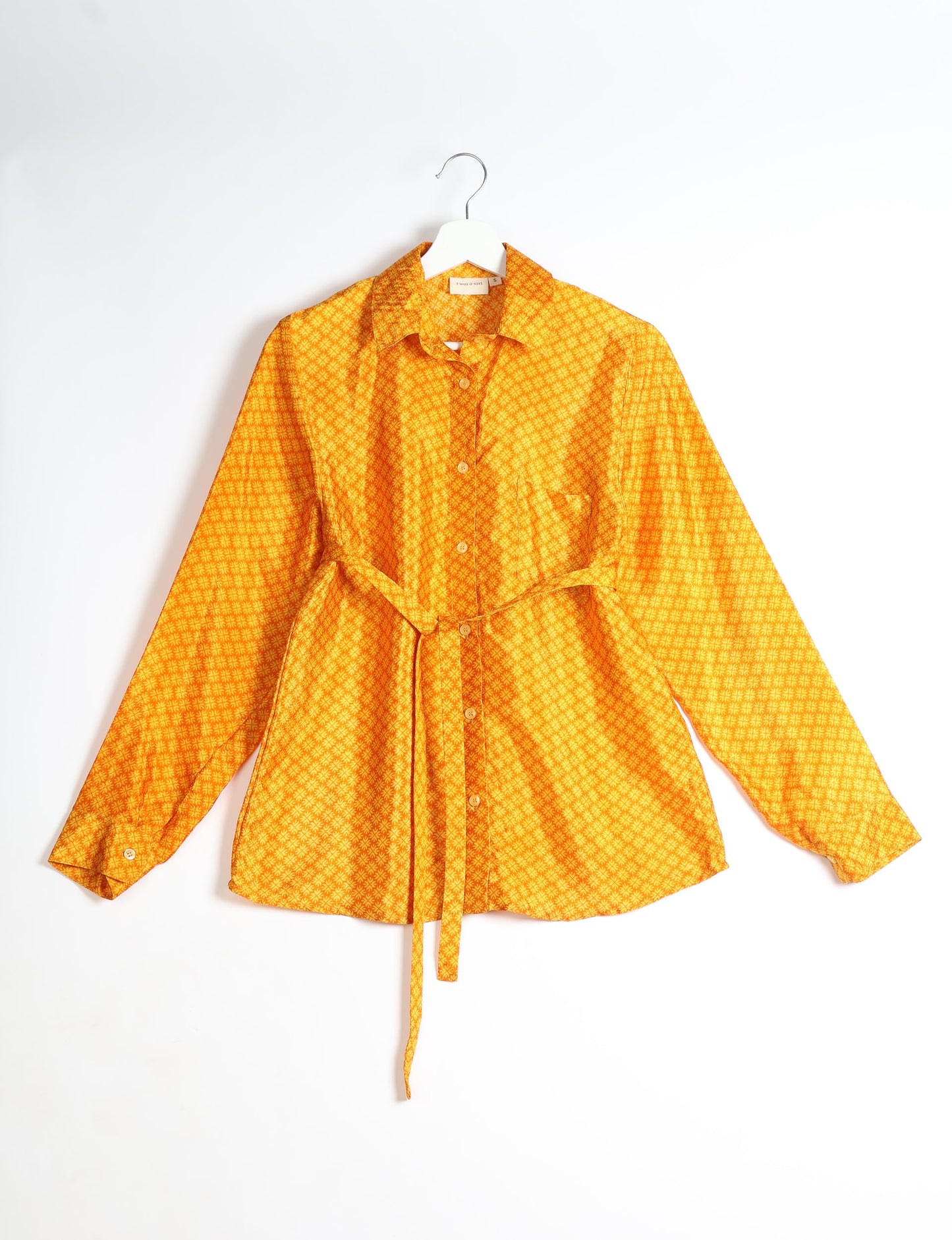 Experience sustainable fashion with our classic slim-fit shirt, crafted with ethical and green values. The shirt, designed for minimal waste, features a tie-up waist belt or neck tie, semi-spread collar, and regular shirt cuffs. Versatile and eco-friendly, wear it tucked in, unbuttoned over a tank top, or knotted at the waist for a unique style.