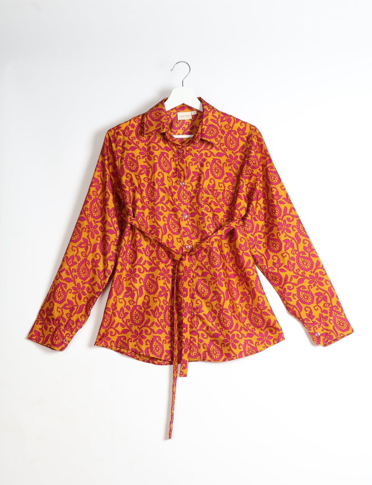 Experience sustainable fashion with our classic slim-fit shirt, crafted with ethical and green values. The shirt, designed for minimal waste, features a tie-up waist belt or neck tie, semi-spread collar, and regular shirt cuffs. Versatile and eco-friendly, wear it tucked in, unbuttoned over a tank top, or knotted at the waist for a unique style.