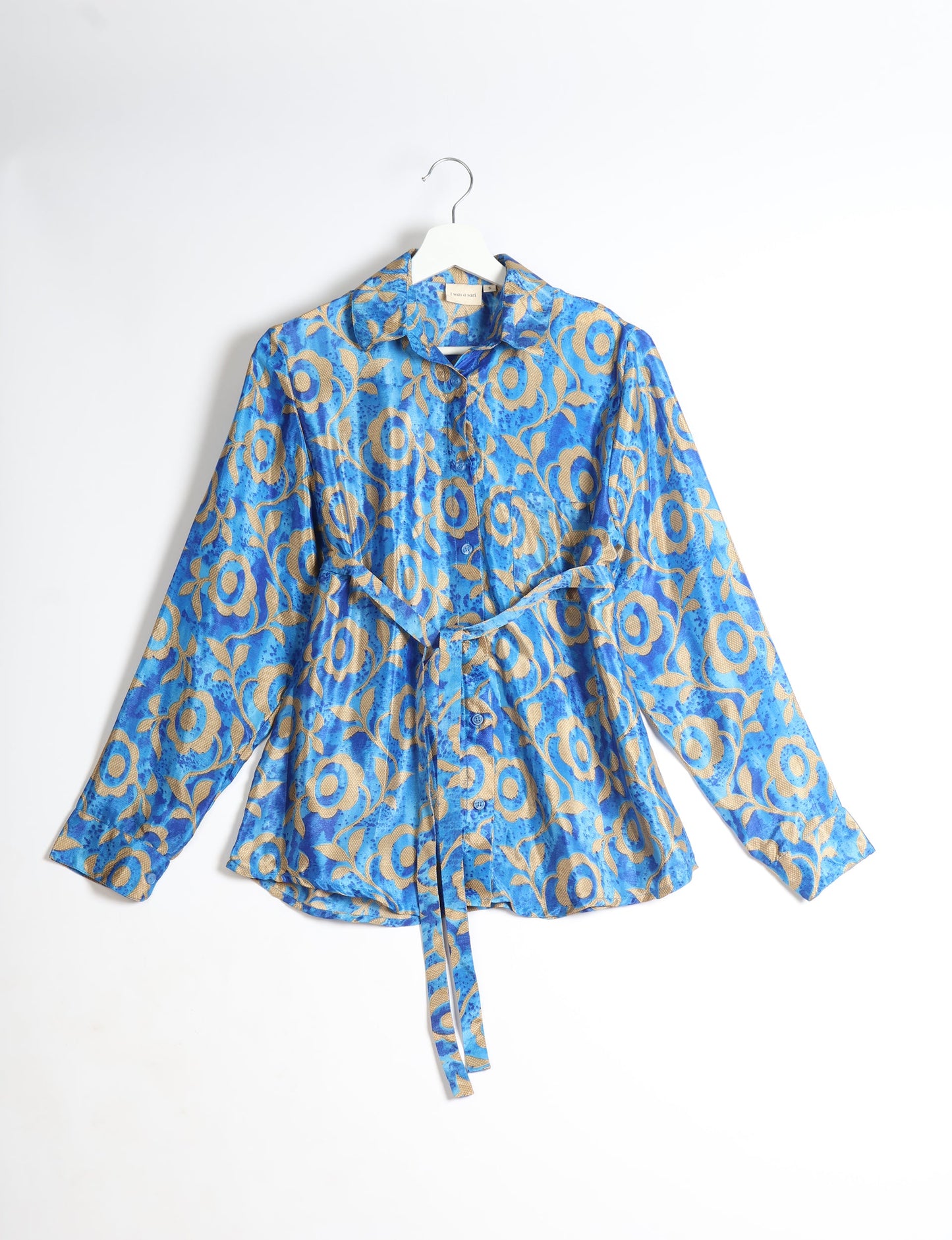 Experience sustainable fashion with our classic slim-fit shirt, crafted with ethical and green values. The shirt, designed for minimal waste, features a tie-up waist belt or neck tie, semi-spread collar, and regular shirt cuffs. Versatile and eco-friendly, wear it tucked in, unbuttoned over a tank top, or knotted at the waist for a unique style.