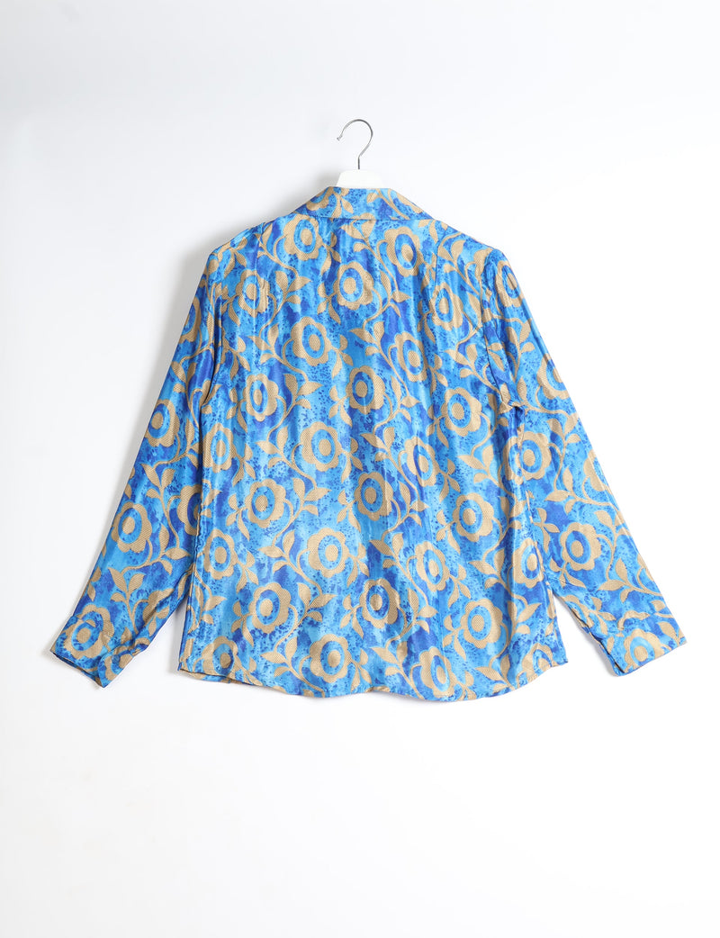 Blue long-sleeve shirt with beige floral pattern, shown from back, hanging on white hanger against white background