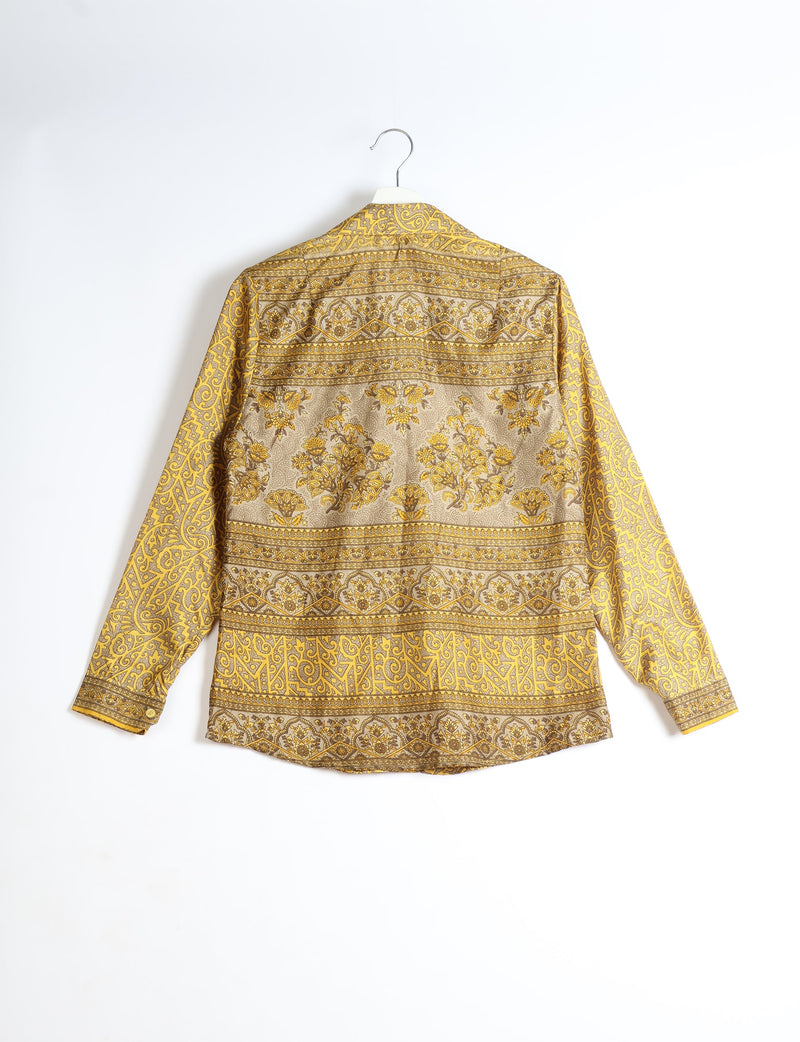 Yellow tropical patterned long-sleeve shirt hanging on a white hanger, back view