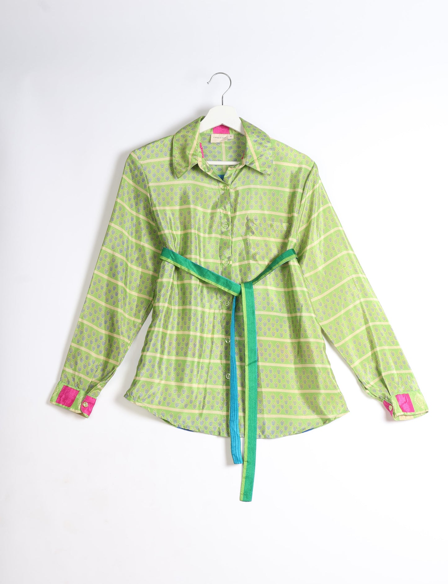 Experience sustainable fashion with our classic slim-fit shirt, crafted with ethical and green values. The shirt, designed for minimal waste, features a tie-up waist belt or neck tie, semi-spread collar, and regular shirt cuffs. Versatile and eco-friendly, wear it tucked in, unbuttoned over a tank top, or knotted at the waist for a unique style.