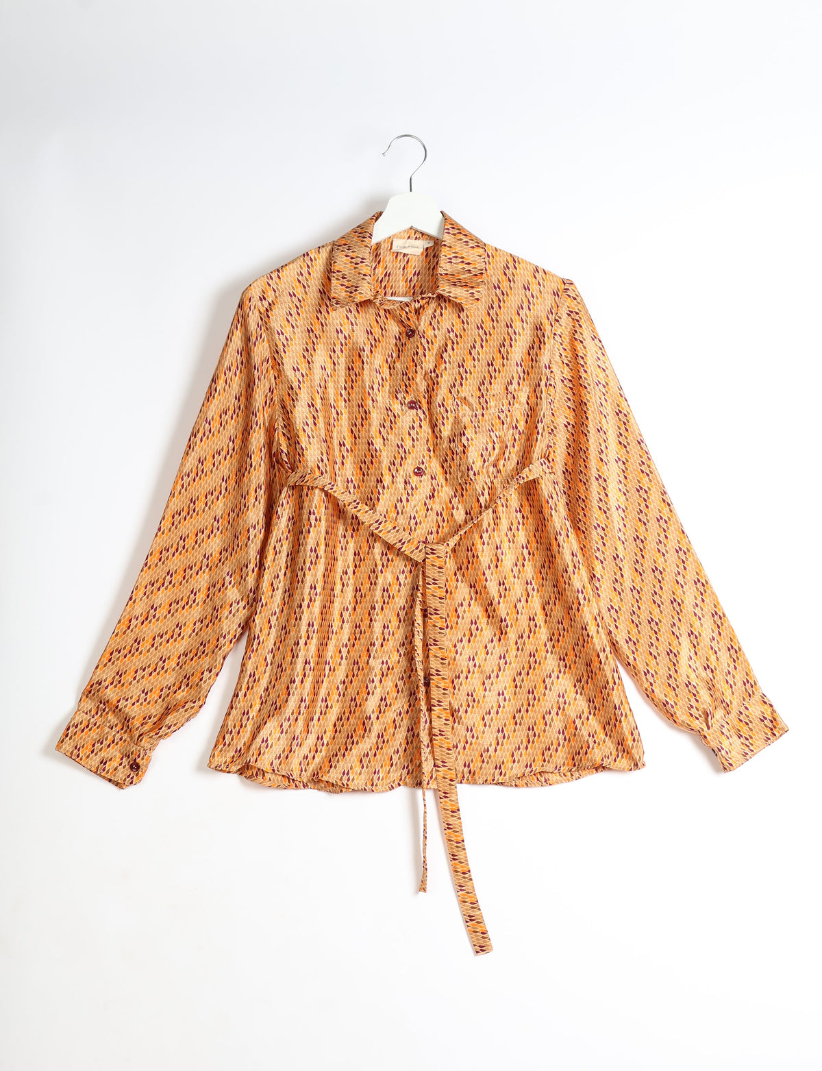 Orange long-sleeve button-up shirt with micro diamond pattern, collar, chest pocket, and waist tie, hanging on white hanger