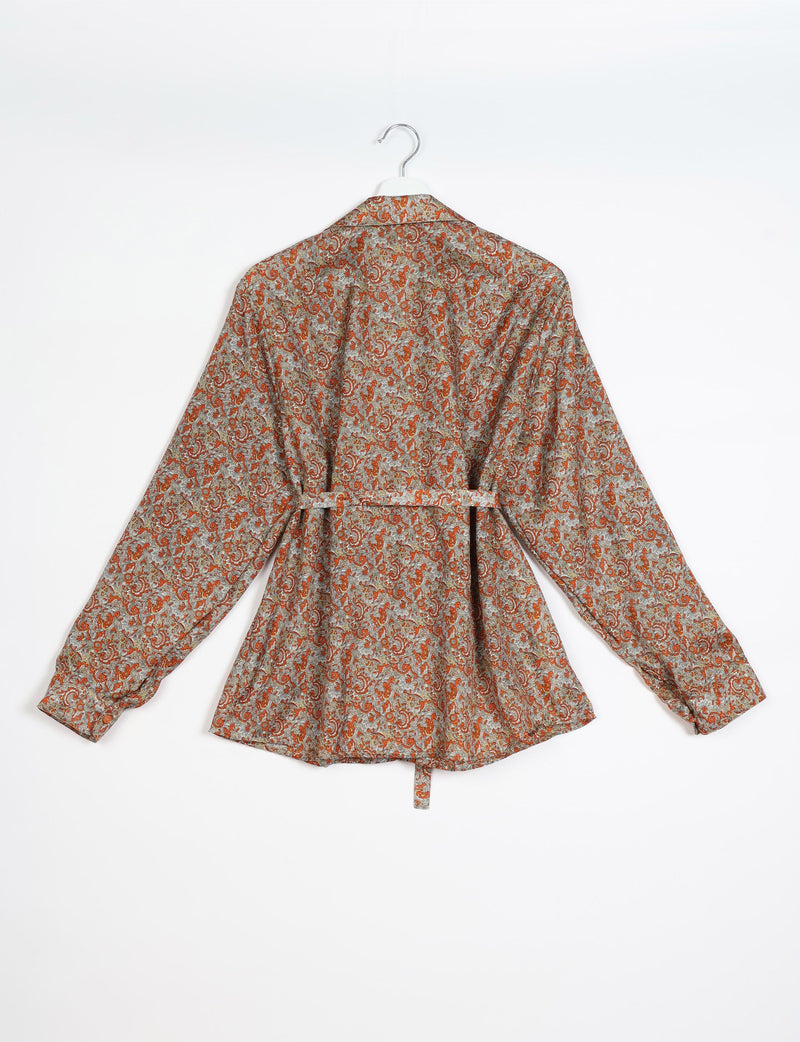 Beige long-sleeve shirt with orange and white tropical paisley pattern, back view, hanging on white hanger