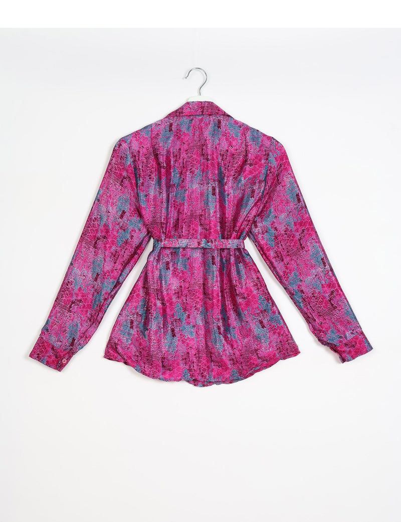 Pink and blue abstract patterned long-sleeve shirt with collar and belt, shown from back on hanger against white background