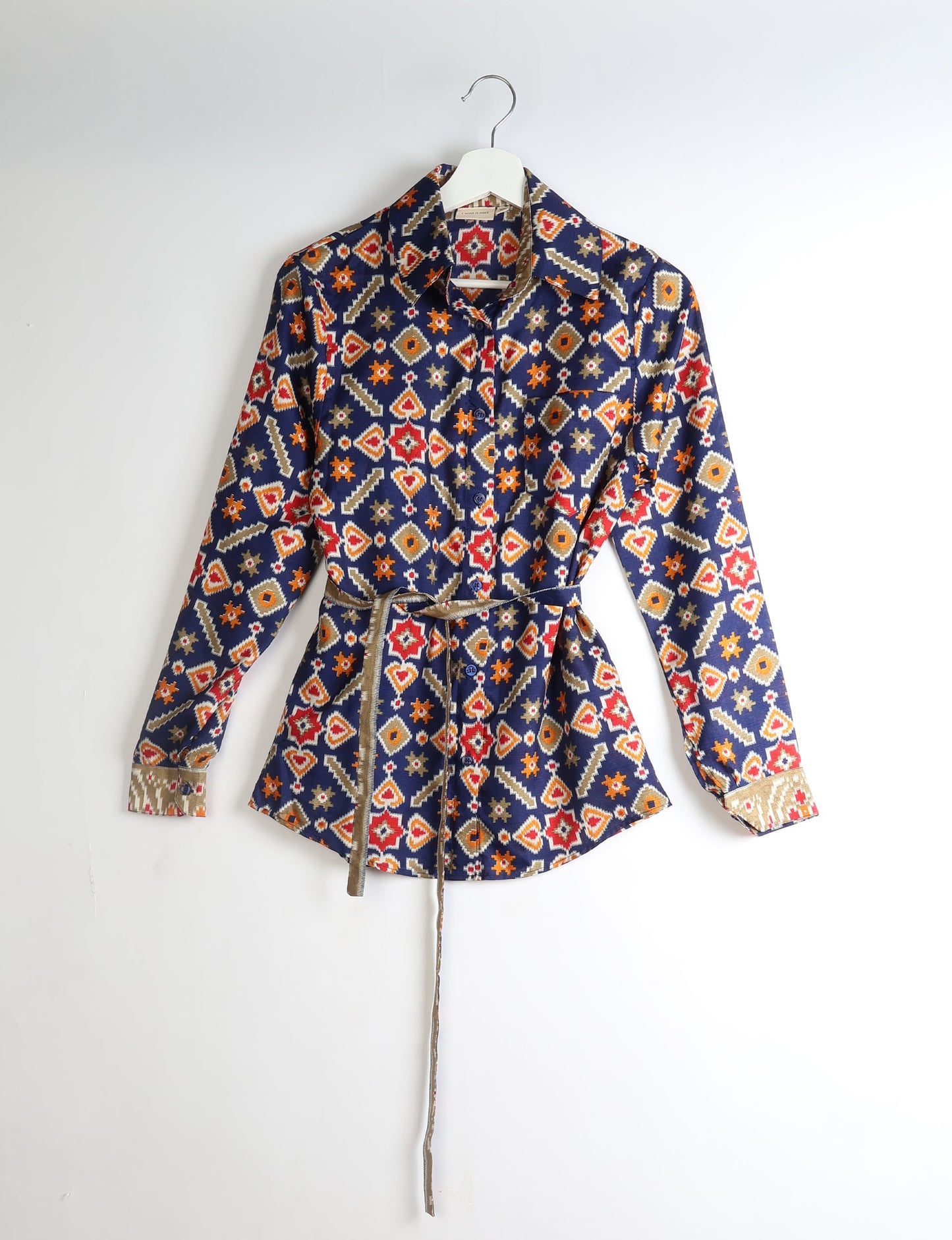 Experience sustainable fashion with our classic slim-fit shirt, crafted with ethical and green values. The shirt, designed for minimal waste, features a tie-up waist belt or neck tie, semi-spread collar, and regular shirt cuffs. Versatile and eco-friendly, wear it tucked in, unbuttoned over a tank top, or knotted at the waist for a unique style.