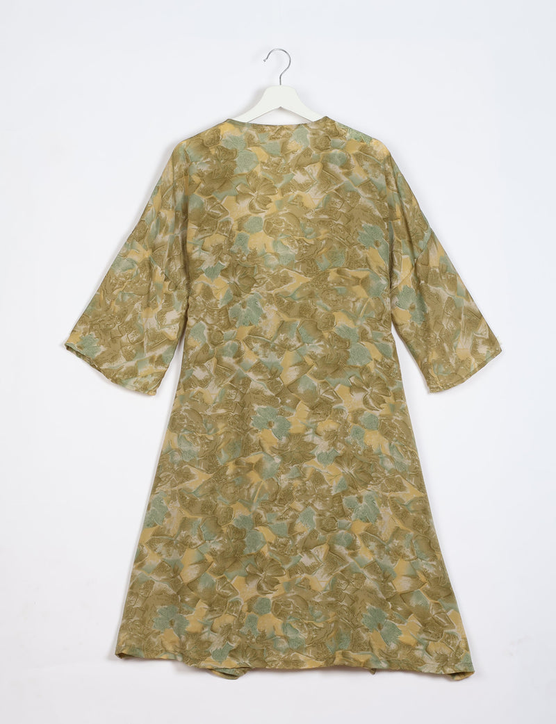 Green and beige abstract patterned coat with wide sleeves hanging on white hanger, back view