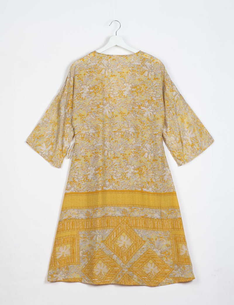 Yellow tropical patterned coat with wide sleeves and geometric border design, shown from back on white hanger