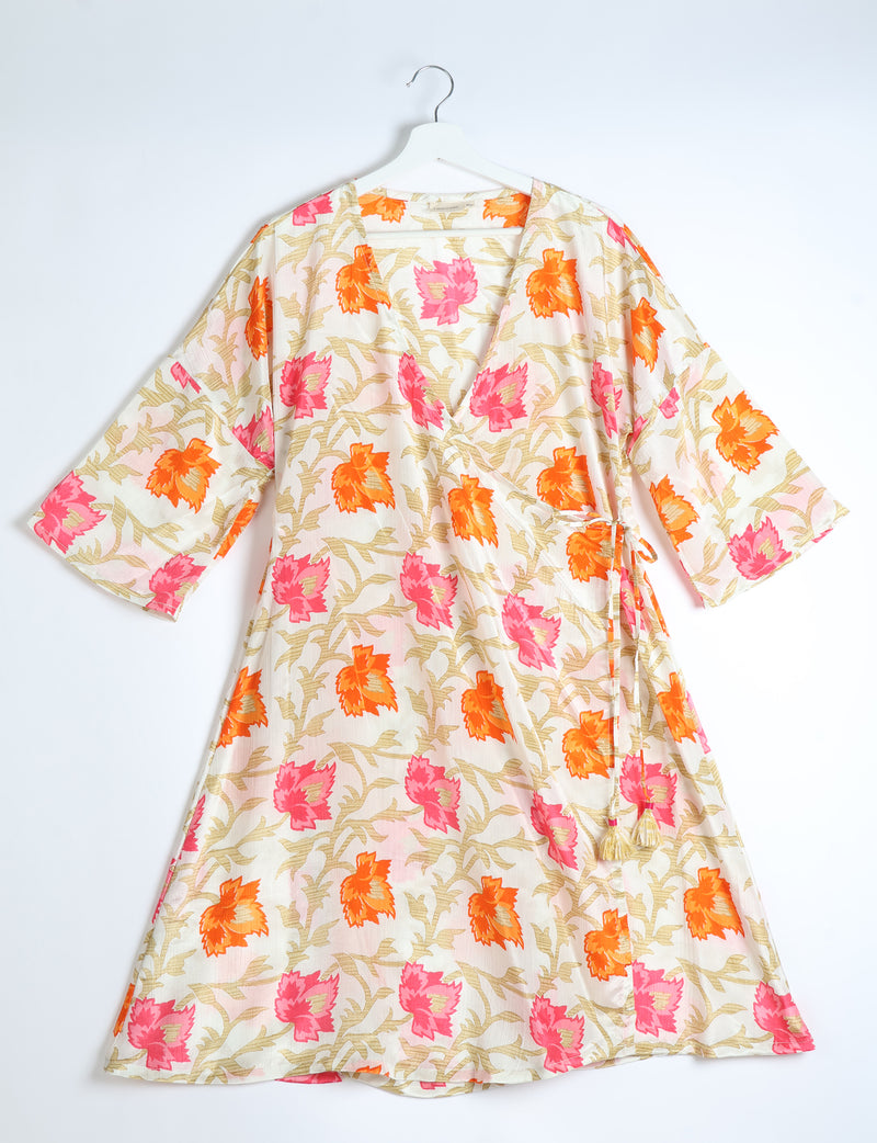 White wrap coat with orange and pink leaf floral print, V-neck, 3/4 sleeves, and side tie with tassels, hanging on white