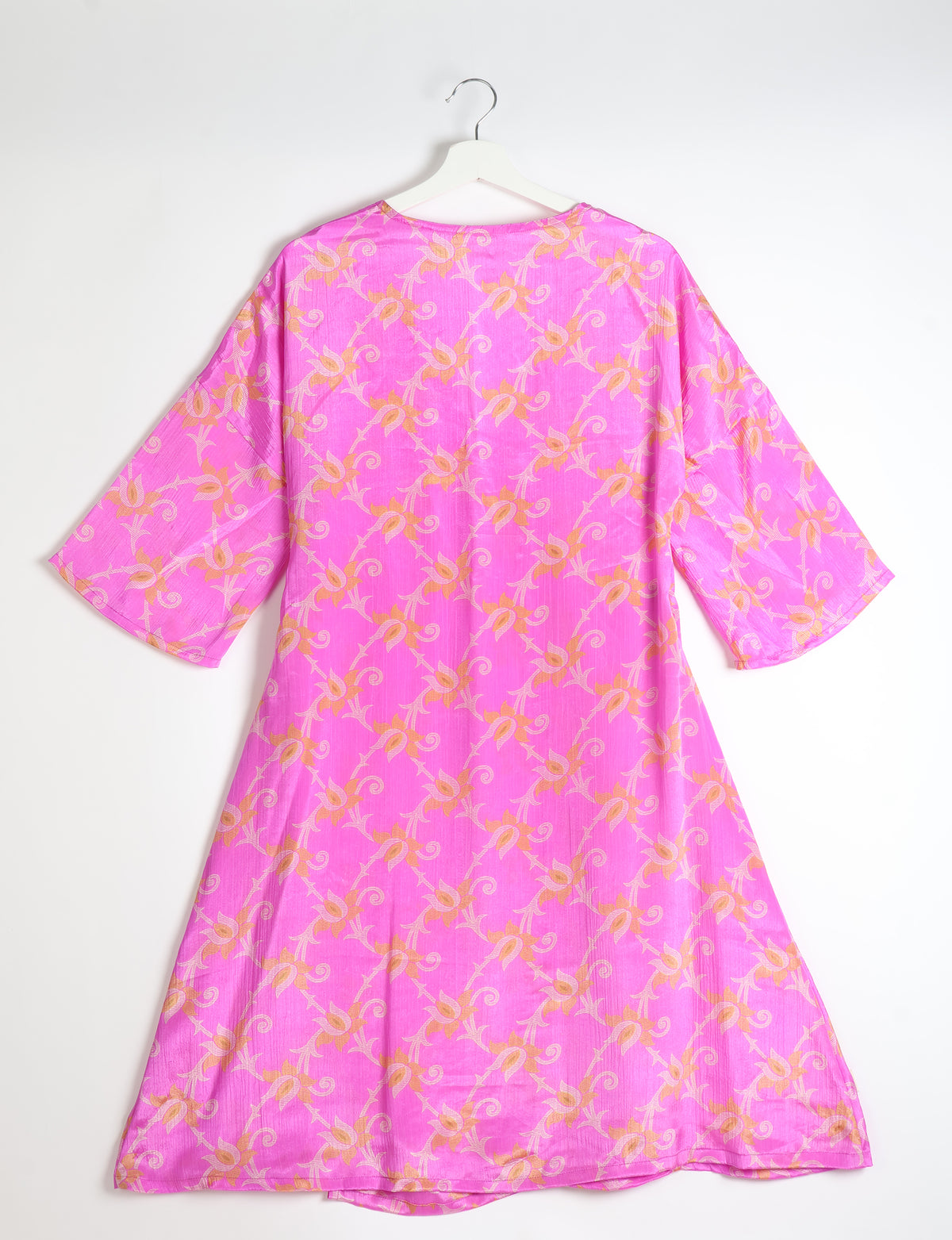 Pink coat with orange floral pattern, wide sleeves, and round neckline, shown from back on white hanger against white