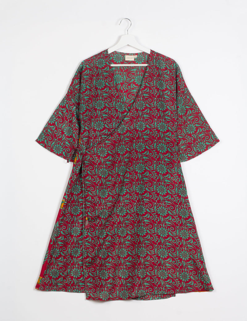 Red floral wrap coat with green flower and swirl pattern, short sleeves, and V-neck, hanging on white hanger