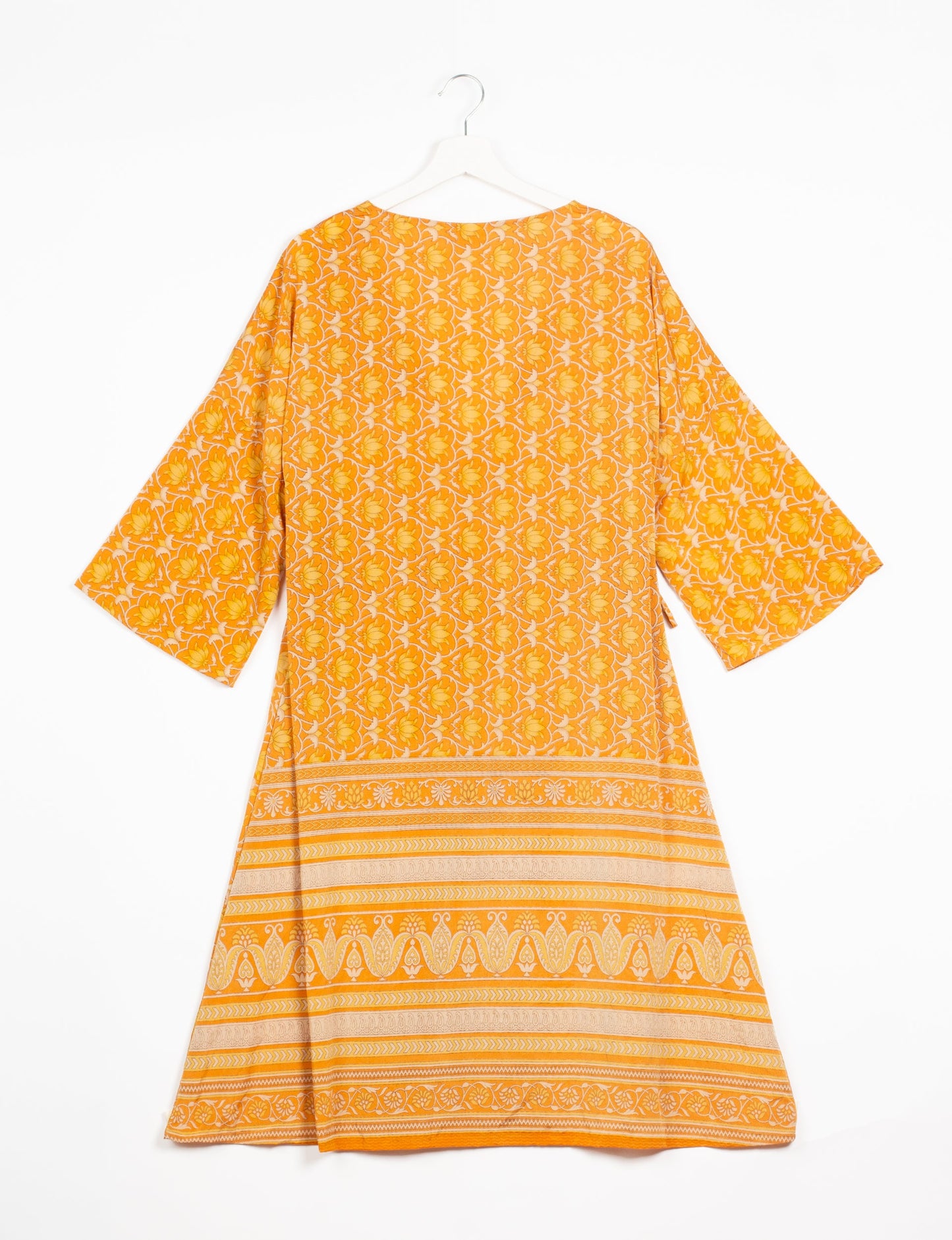 Elevate your style with our Sunset Coat, a shin-length wrap featuring a deep V-neck, wide flared 3/4 sleeves, and side tie with thread tassels. Embrace ethical and sustainable fashion with this zero waste, upcycled garment. A perfect blend of elegance and whimsy for conscious clothing enthusiasts.