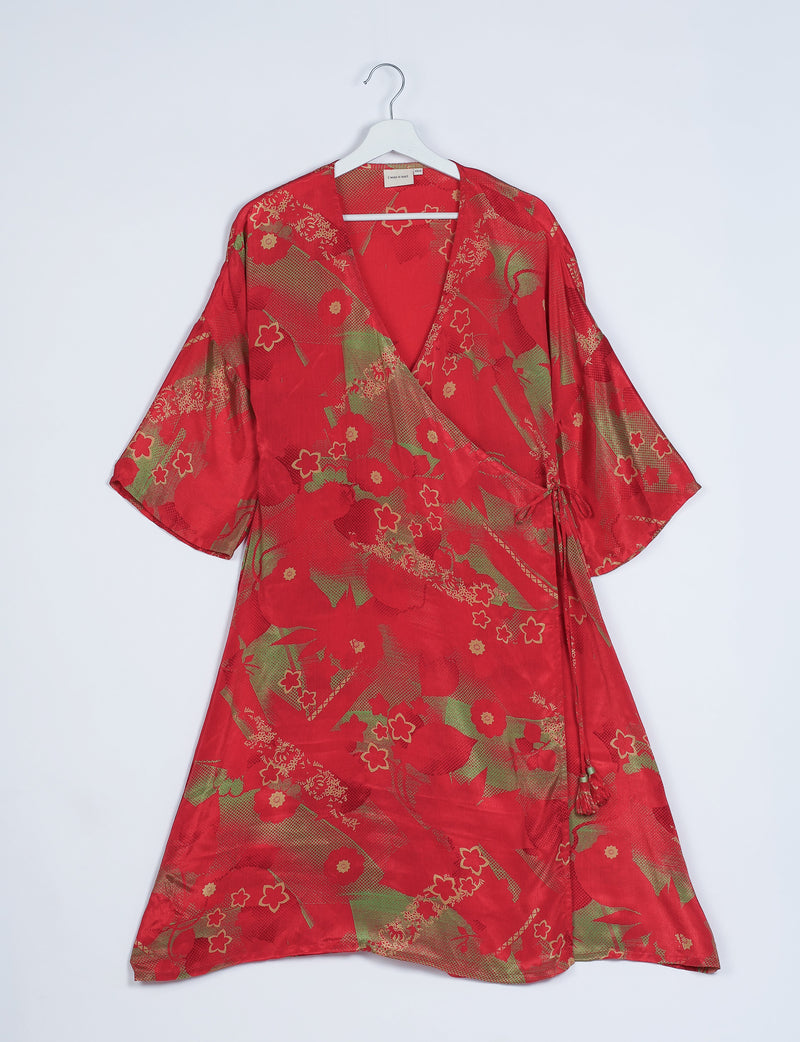 Red wrap coat with abstract floral and geometric patterns in green and beige, hanging on white hanger, front view