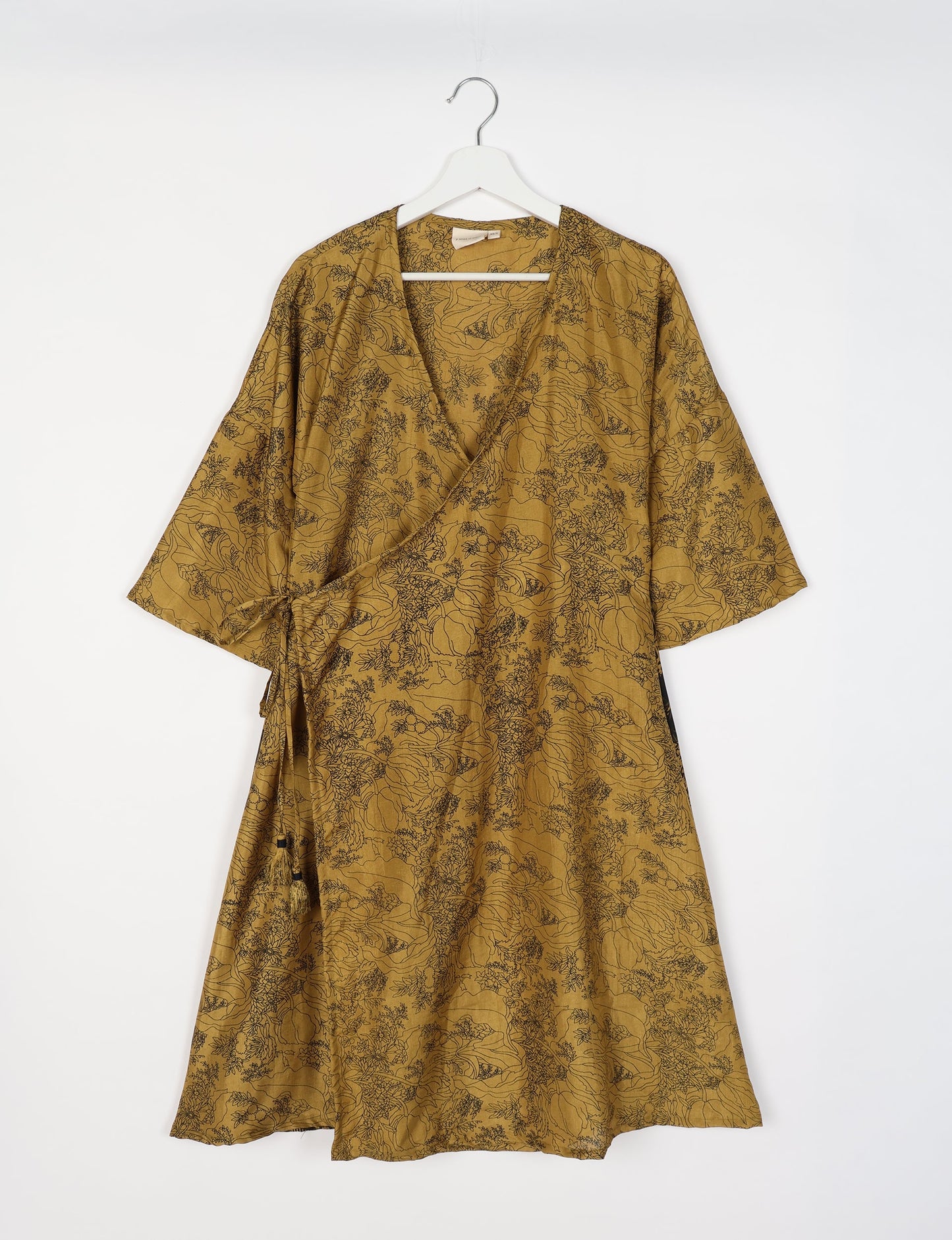 Elevate your style with our Sunset Coat, a shin-length wrap featuring a deep V-neck, wide flared 3/4 sleeves, and side tie with thread tassels. Embrace ethical and sustainable fashion with this zero waste, upcycled garment. A perfect blend of elegance and whimsy for conscious clothing enthusiasts.