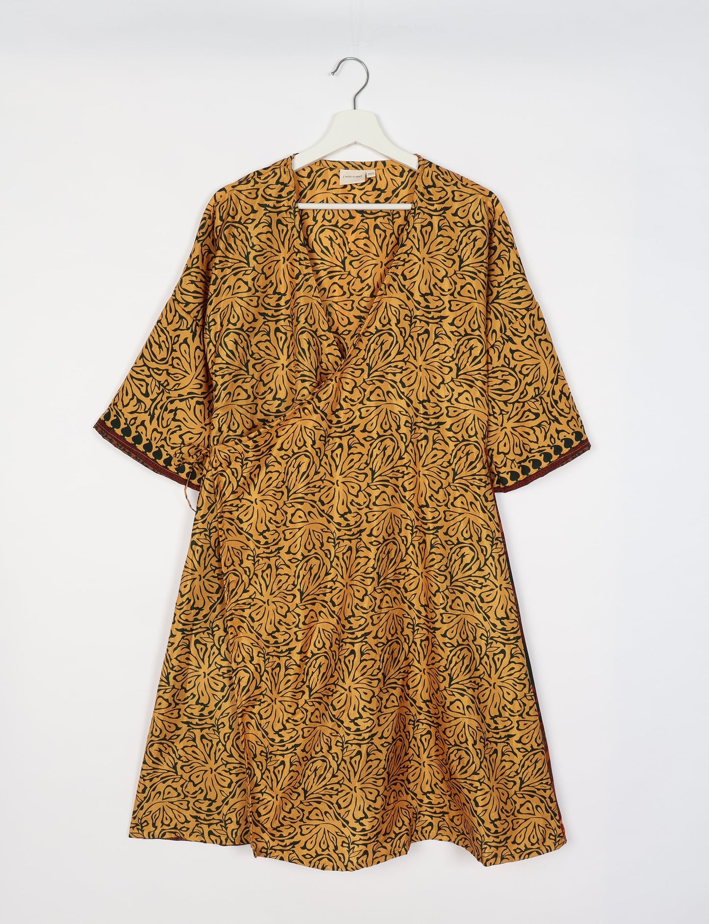 Elevate your style with our Sunset Coat, a shin-length wrap featuring a deep V-neck, wide flared 3/4 sleeves, and side tie with thread tassels. Embrace ethical and sustainable fashion with this zero waste, upcycled garment. A perfect blend of elegance and whimsy for conscious clothing enthusiasts.