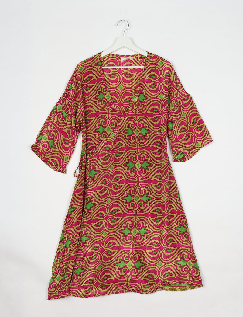 Pink paisley wrap coat with green and gold ornate swirl pattern, three-quarter sleeves, hanging on white hanger front view