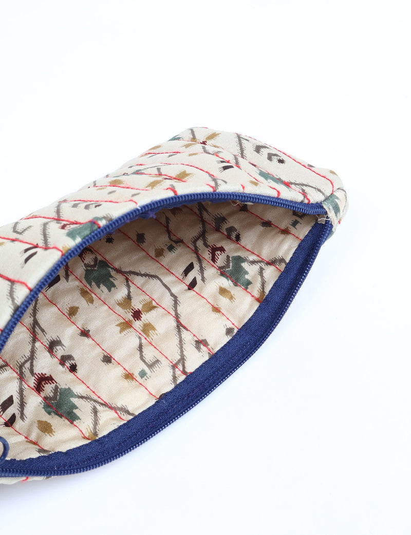 Quilted pencil pouch with blue zipper, beige fabric featuring red stitching and multicolor Indian ethnic floral print, open