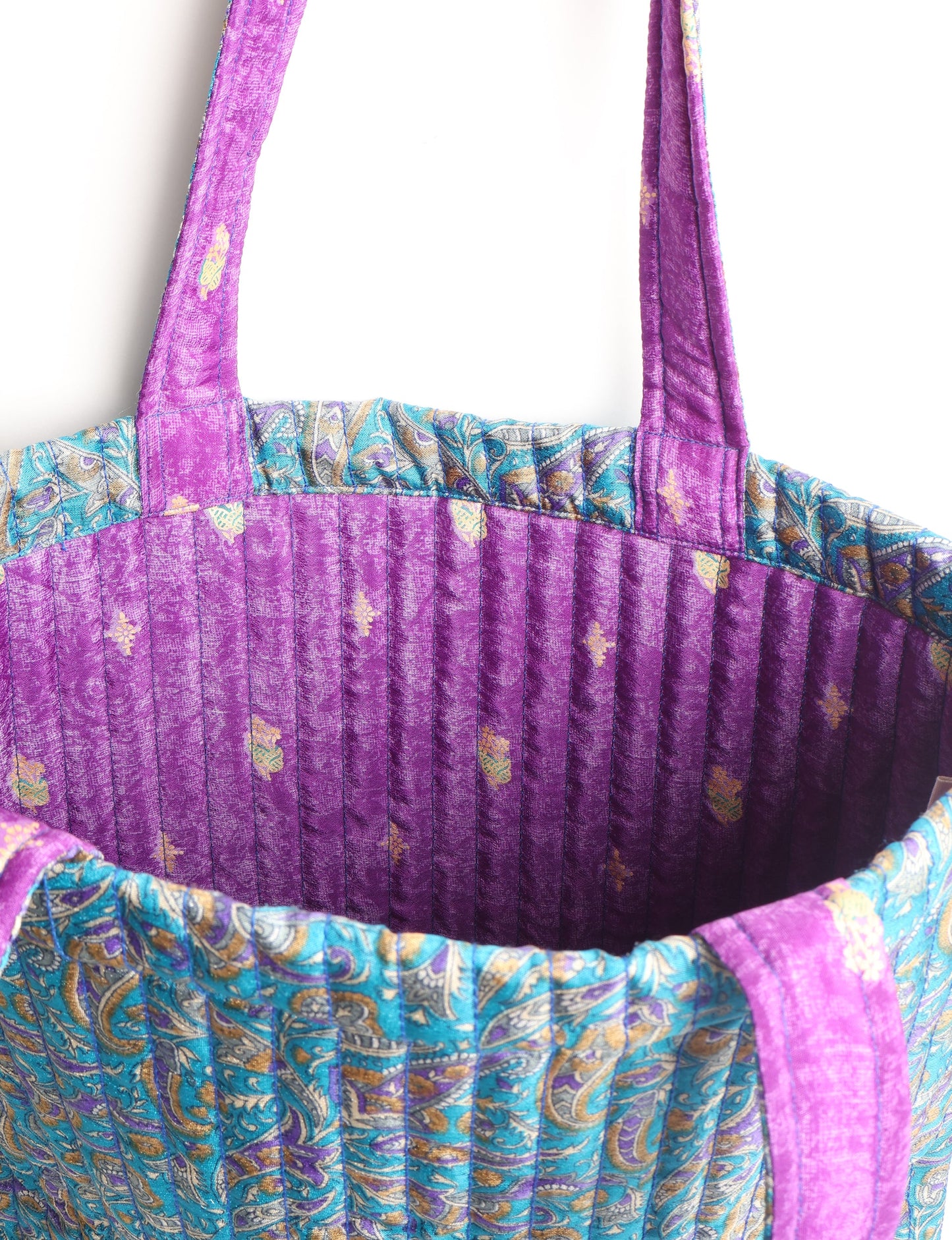 Elevate your style sustainably with our QUILTED SHOPPER BAG. Soft textures, vibrant colors, and a positive impact on people and the planet. Perfect for the office, shopping, or happy hour. Crafted from pre-loved saris for eco-conscious fashionistas!