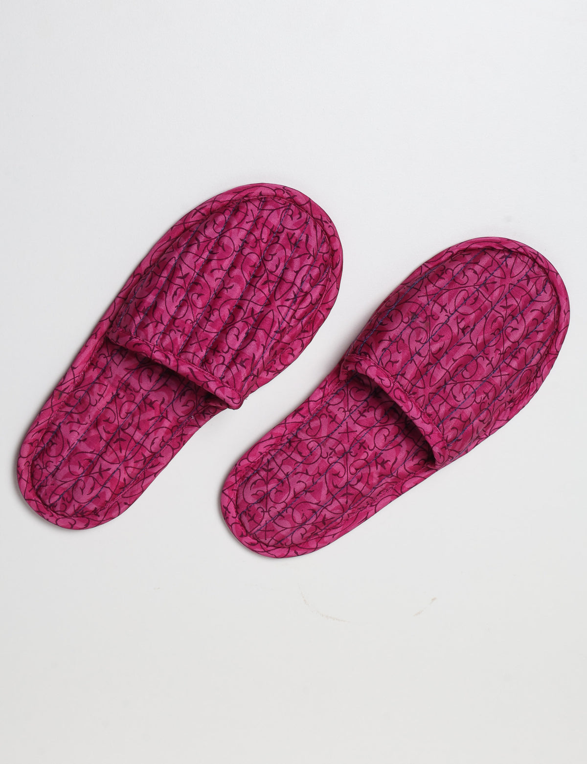 Blue quilted slippers with paisley pattern, open back, and cushioned footbed, shown flat on white background