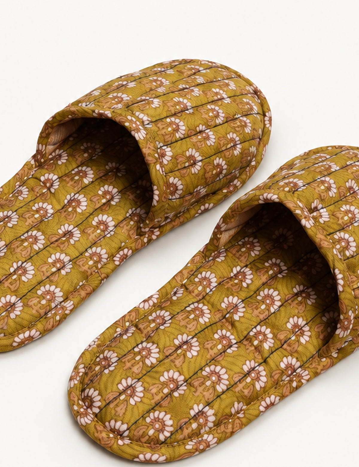 Blue quilted slippers with paisley pattern in shades of purple, green, and pink, shown from top view on white background