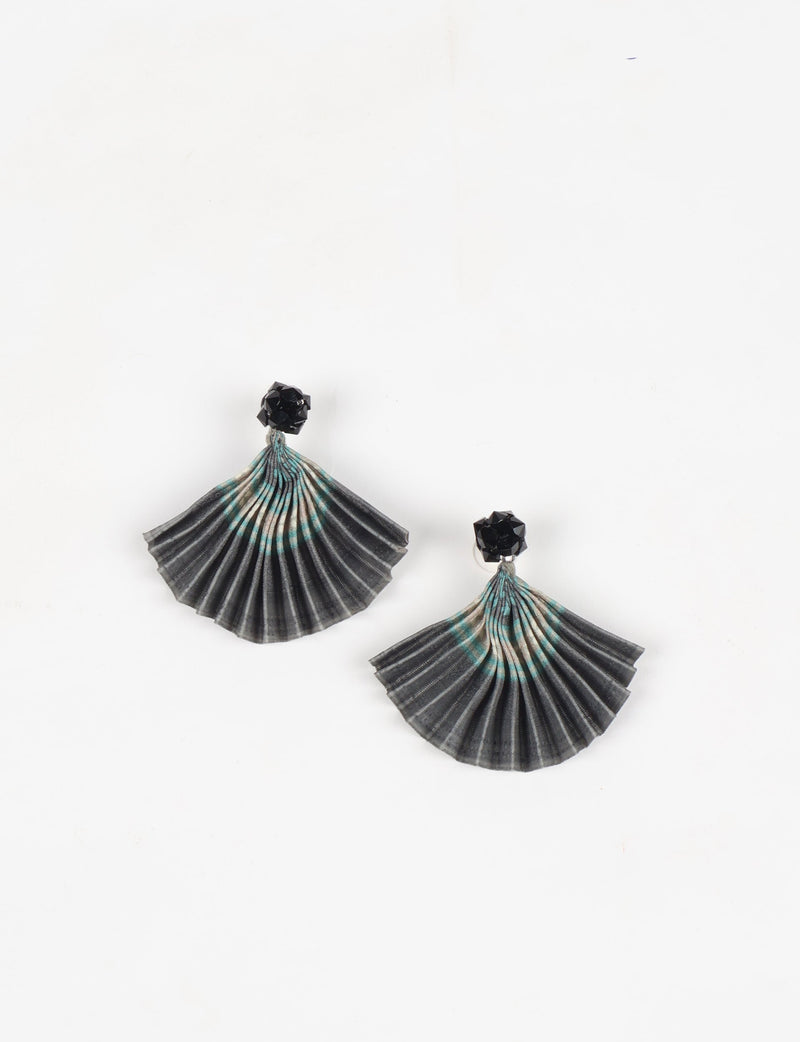 Grey pleated fabric earrings with abstract turquoise and beige pattern and black faceted stud tops, flat lay on white background