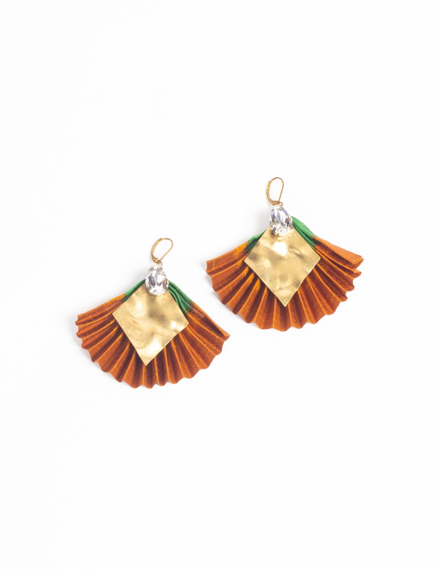 Elevate your style sustainably with our PLEATED EARRINGS – a fusion of ethical fashion and eco-conscious design. Created from pre-loved saris using heat set pleats, these earrings embody zero waste clothing and upcycled fashion. Fastened with hooks, adorned with a diamond-shaped metallic plate and a special drop-shaped jewel. Hypoallergy tested metal hooks, nickel, and lead-free, making them a conscious and skin-friendly accessory.