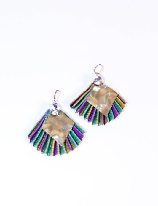 Elevate your style sustainably with our PLEATED EARRINGS – a fusion of ethical fashion and eco-conscious design. Created from pre-loved saris using heat set pleats, these earrings embody zero waste clothing and upcycled fashion. Fastened with hooks, adorned with a diamond-shaped metallic plate and a special drop-shaped jewel. Hypoallergy tested metal hooks, nickel, and lead-free, making them a conscious and skin-friendly accessory.