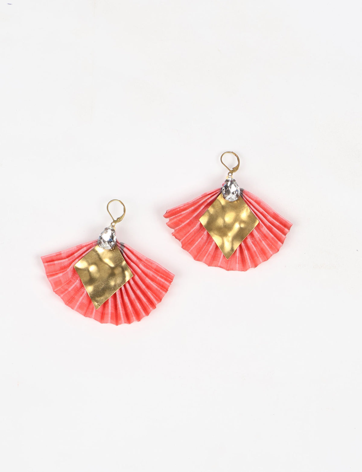 Pink pleated fabric earrings with hammered gold diamond-shaped metal and clear teardrop crystals, shown flat on white background