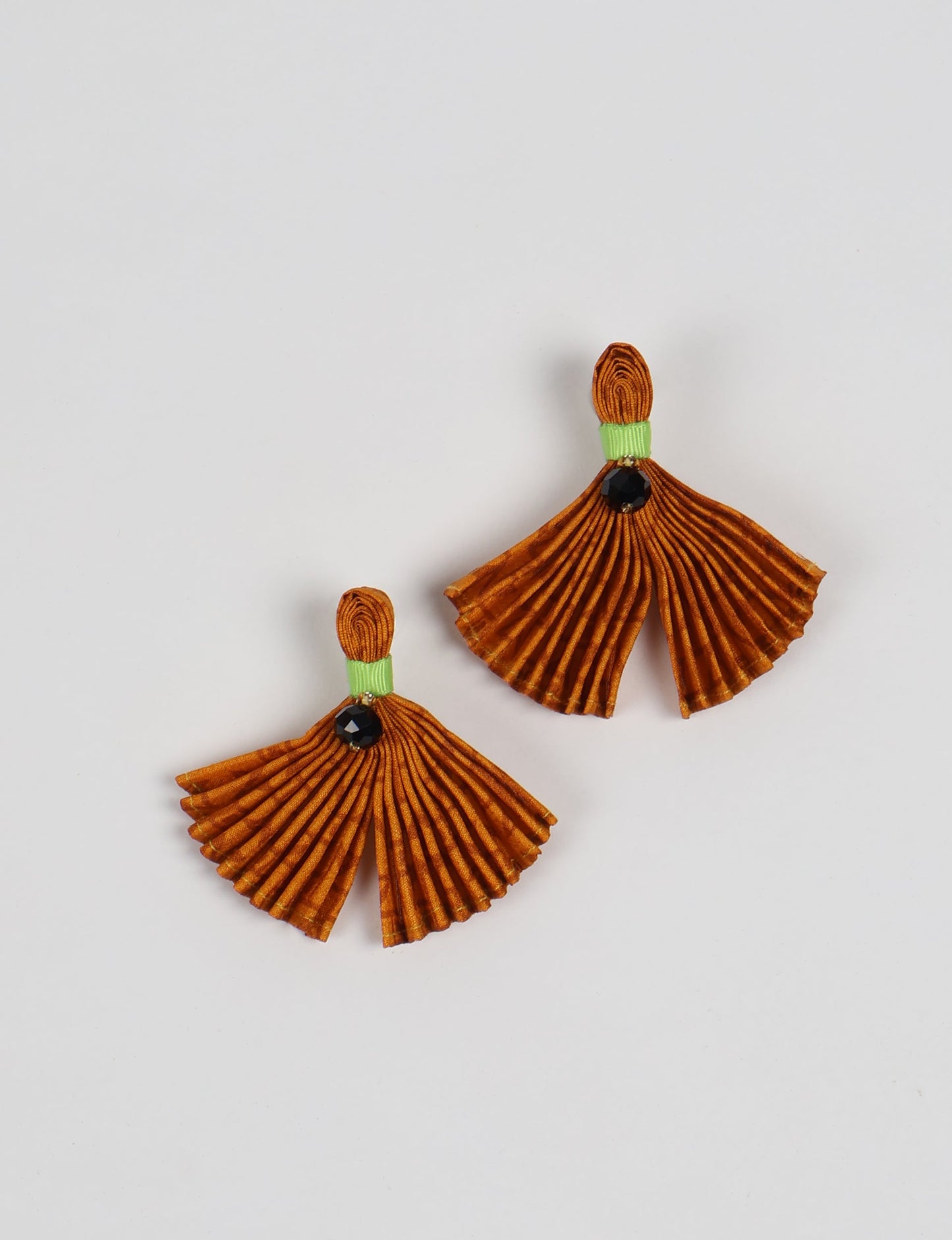 Adorn yourself sustainably with our PLEATED EARRINGS – fan-shaped wonders with a top knot and a tiny stone. Meticulously hand-pleated from Indian saris, these earrings reflect ethical clothing, green fashion, and slow fashion. Fastened with hypoallergy tested metal hooks, nickel, and lead-free, making them a conscious and stylish accessory.
